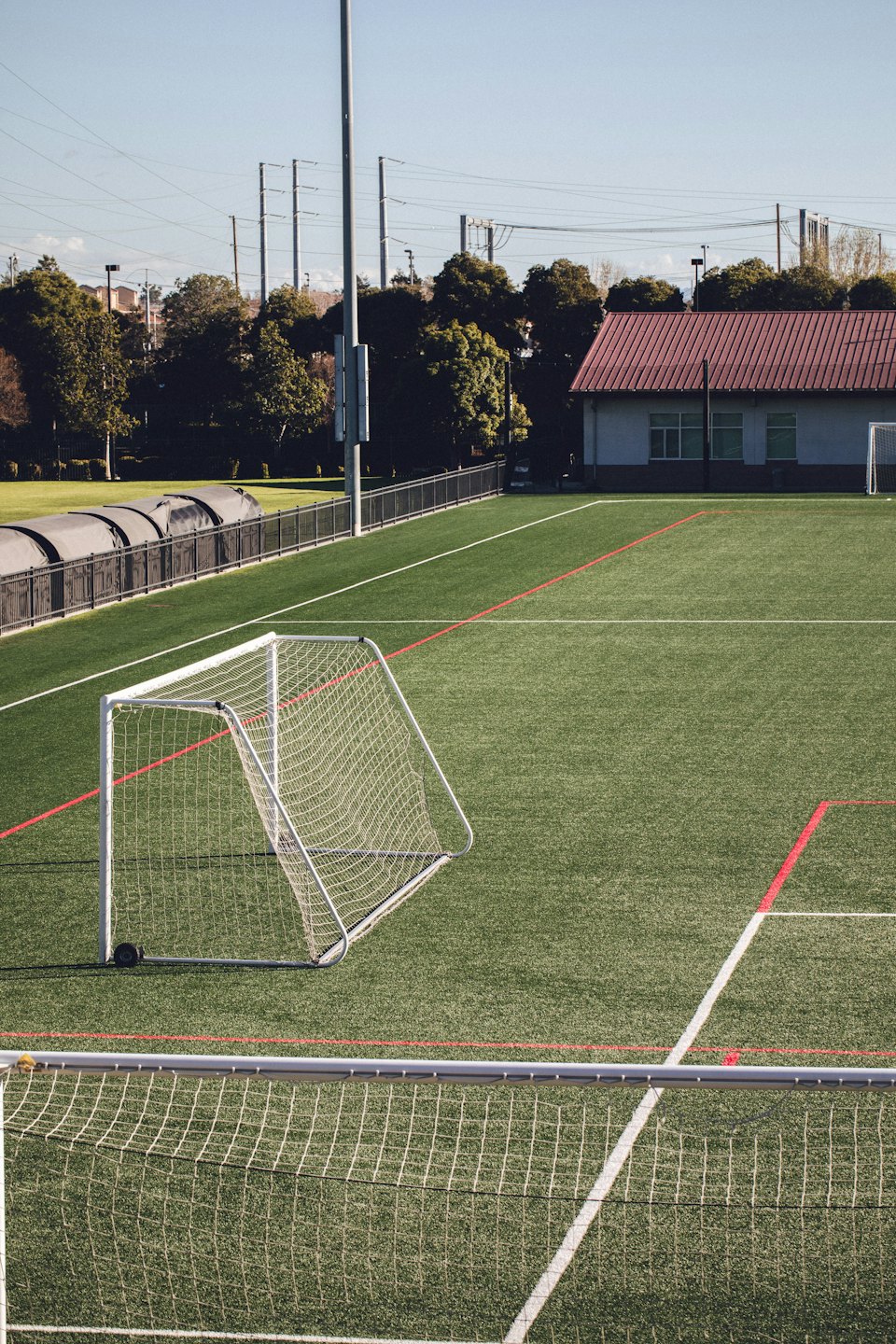 Voetbalveld met doelen en felgroen kunstgras.